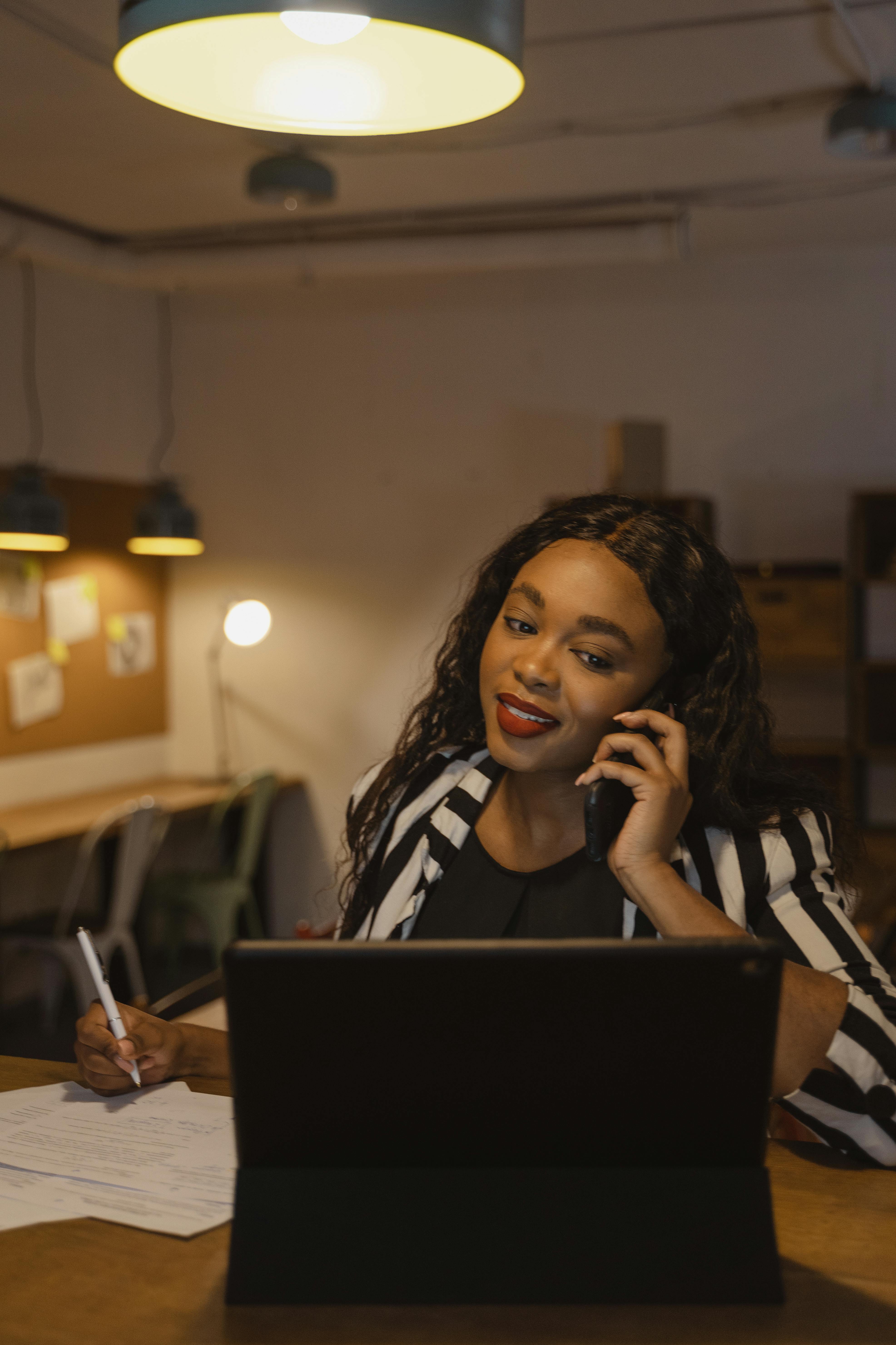 Image of working woman on a call while working on computer